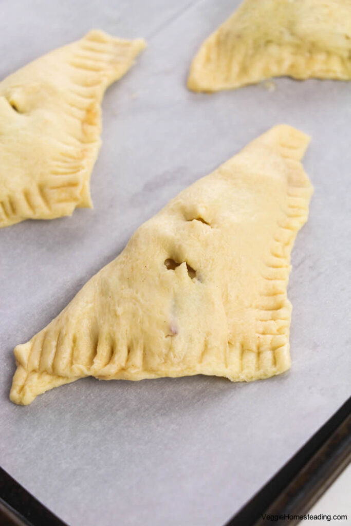 Step-by-step process of folding and sealing puff pastry turnovers with apple filling